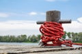 Worn old rusty mooring bollard with heavy ropes on the deck of a ship, closeup. Royalty Free Stock Photo