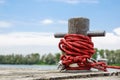 Worn old rusty mooring bollard with heavy ropes on the deck of a ship, closeup. Royalty Free Stock Photo