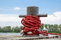 Worn old rusty mooring bollard with heavy ropes on the deck of a ship, closeup. Royalty Free Stock Photo