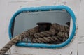 Worn old rusty mooring bollard with heavy ropes on the deck of a ship, closeup Royalty Free Stock Photo