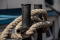 Worn old rusty mooring bollard with heavy ropes on the deck of a ship, closeup Royalty Free Stock Photo