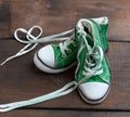 Worn old textile green sneakers with untied white laces Royalty Free Stock Photo