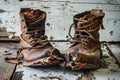 Worn-out and heavily damaged boots, with separated soles, torn uppers, and exposed insides