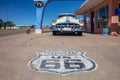 Worn out stamp of route 66 on the pavement in front of an antique pontiac car. Tucumcari, New Mexico, US