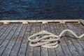 Worn out thick mooring rope on wooden pier. Can use as banner. Place for text or advertising
