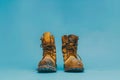 Worn-out work boots on blue background