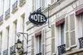 The worn period sign of an hotel and a vintage street light fixed to an old building in Paris Royalty Free Stock Photo