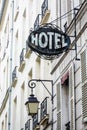 The worn period sign of an hotel and a vintage street light fixed to an old building in Paris Royalty Free Stock Photo