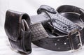 A worn police duty belt with a black pistol and handcuff case wrapped up