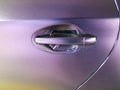 Worn purple wrap on automobile with door handle