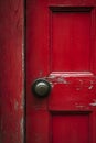 A worn red door with a traditional doorknob.