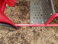 Worn red metal play structure and brown mulch