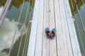 Worn shoes on wooden boards of a suspension bridge