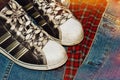 Worn sneakers on the denim jacket ans checkered shirt Royalty Free Stock Photo