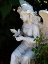 Statue Of Female Angel Holding Bird In Garden Royalty Free Stock Photo