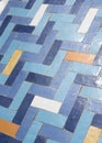 Worn tiled floor in Herringbone pattern, in blue, orange, and white