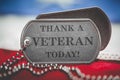 Worn US American dog tags on USA flag with Thank a Veteran Today text Royalty Free Stock Photo