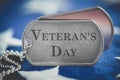 Worn US American dog tags on USA flag with Veteran`s Day text