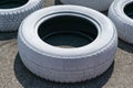 Worn used car tire, painted white for identification