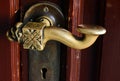 Worn weathered old classic bronze handle with key hole. brown stained wooden door. macro view. Royalty Free Stock Photo