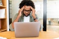 Worried african-american male employee colleague staring at laptop screen sitting on the workplace Royalty Free Stock Photo