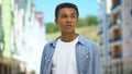 Worried Afro-American teen boy standing outdoors, waiting for friends late Royalty Free Stock Photo