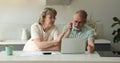 Retired couple check bank account using laptop annoyed with overspending