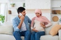 Worried arab husband calling doctor or ambulance while his pregnant wife having labor pains and touching her big tummy