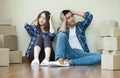 Worried Asian couple sitting with cardboard boxes In their new h Royalty Free Stock Photo