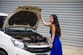 Worried Asian Japanese woman in stress stranded on street roadside with car engine failure having mechanic problem needing repair Royalty Free Stock Photo