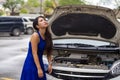 Worried Asian Japanese woman in stress stranded on street roadside with car engine failure having mechanic problem needing repair Royalty Free Stock Photo