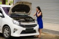 Worried Asian Korean woman in stress stranded on street roadside with car engine failure having mechanic problem needing repair Royalty Free Stock Photo