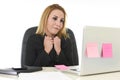 Worried attractive businesswoman in stress working with laptop computer at office desk overwhelmed and overworked Royalty Free Stock Photo