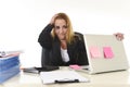 Worried attractive businesswoman in stress working with laptop computer at office desk overwhelmed and overworked