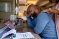 Worried biracial couple using laptop and looking at bills in dining room, copy space Royalty Free Stock Photo