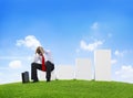 Worried Business Man Sitting on a Bar Graph Royalty Free Stock Photo