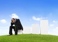 Worried Business Man Sitting on a Bar Graph Royalty Free Stock Photo