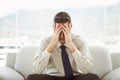 Worried businessman with head in hands sitting on couch Royalty Free Stock Photo