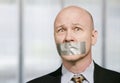 Worried businessman muzzled with duct tape