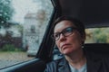 Worried businesswoman with eyeglasses waiting in the car and looking out the window during rain Royalty Free Stock Photo