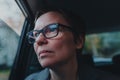Worried businesswoman with eyeglasses waiting in the car and looking out the window during rain Royalty Free Stock Photo