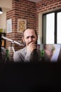 Worried caucasian man sitting at home while watching tragic news event online video on laptop.