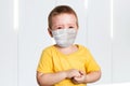 Worried child wearing a protective face mask to prevent corona virus infection or pollution
