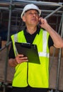 Worried Male Builder Architect Contractor on Building Site Using Phone