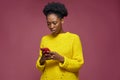 Worried confused irritated african american woman holding mobile phone, reading bad news in message annoyed by spam Royalty Free Stock Photo