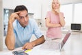 Worried couple with bills and laptop in kitchen Royalty Free Stock Photo