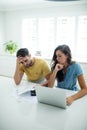 Worried couple calculating their bills with laptop in the kitchen Royalty Free Stock Photo