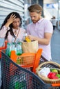 worried couple checking grocery receipt at supermarket