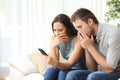 Worried couple reading bad news on the phone