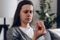 Worried depressed young woman holding wedding ring sitting alone on couch, breaking off engagement, ending relationship, abandoned Royalty Free Stock Photo